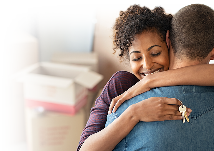 Photo of a happy couple with a young woman hugging a young man with a set of house keys in her hands. Photo of a happy couple with a young woman hugging a young man with a set of house keys in her hands.